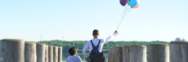 Kinder mit Luftballons auf einem Steg