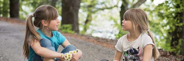 zwei sich unterhaltende Kinder auf einem Weg