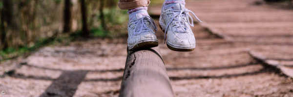 Balancieren auf einem Holzstamm in einem Park